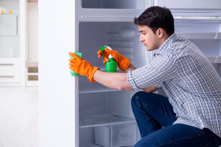 caucasion man cleaning fridge