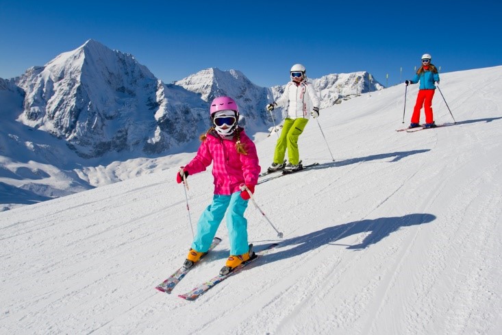 family skiing down mountain